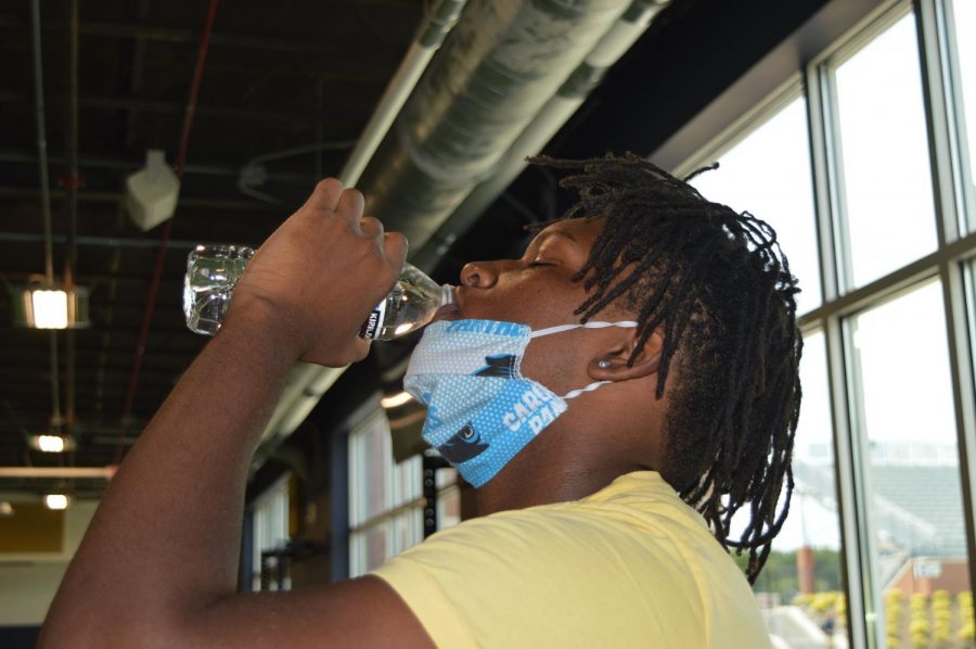 While working out during 6th period Weight Training, Mehki Wilson (10) focuses on hydrating to help reduce muscle cramps, headaches and fatigue.