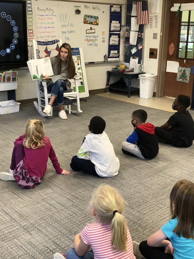 Enthusiastically sharing a story with her class, Teacher Cadet Elise Bryant (12) helps to install the importance of reading to first graders at Pine Street Elementary.