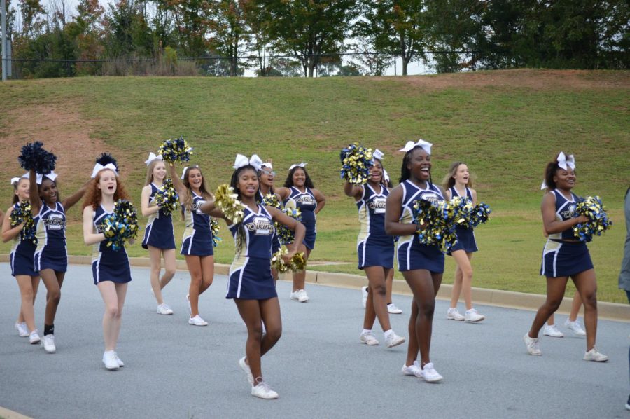 The Varsity cheerleaders lead the crowd during the Homecoming parade.