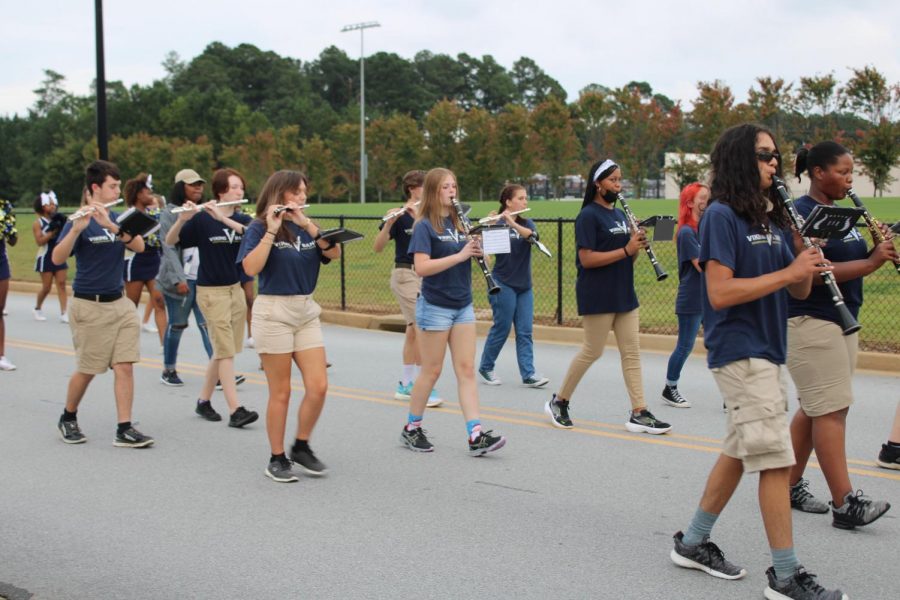 Marching band students perform during the Homecoming parade.