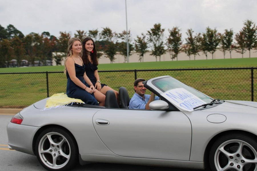 Annie Colbath (12) and Makayla Durham (12), two Homecoming queen candidates, ride through the parade.
