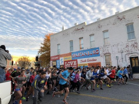 Runners gather in front of the downtown landmark Love Where Your Live Mural to begin the 8k race.