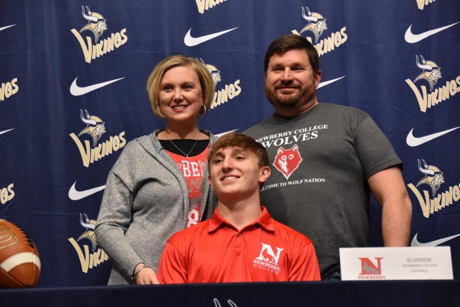 John David Lawson (12) smiles with his family after signing.
