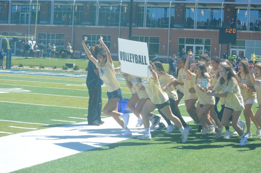 The Vikings volleyball team run onto the field during the Pep Rally.