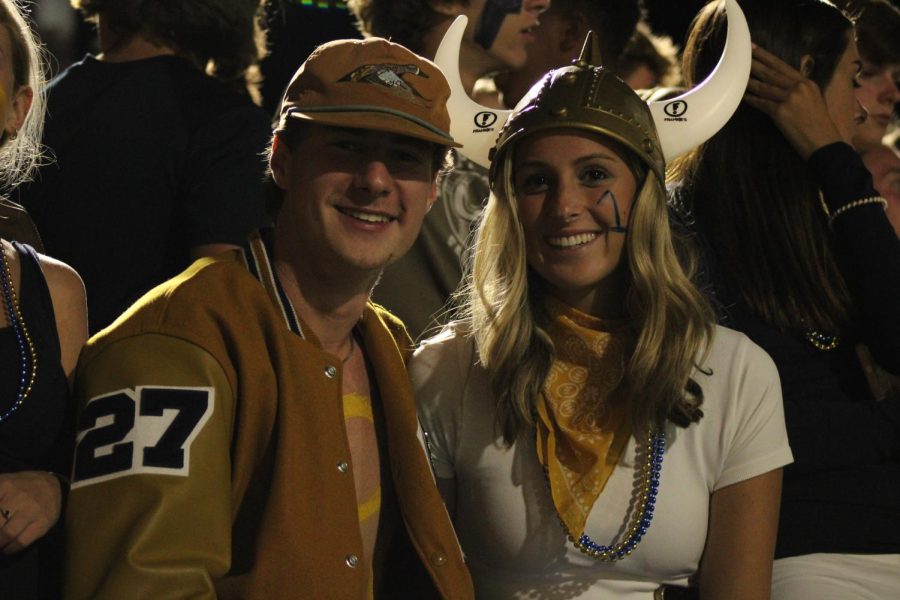Jack Krydynski (12) and Eva Pye (12) smile from the spirited student section at the Homecoming football game on Friday, Sept. 23. 
