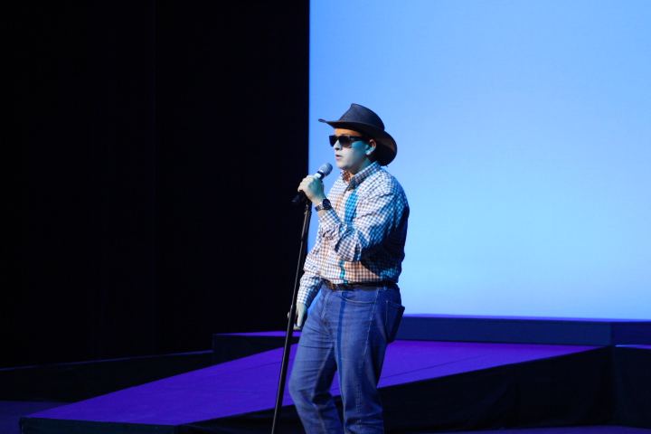 Charlie Millinor (12) performs How Do You Like Me Now by Toby Keith while dressed in cowboy boots and a cowboy hat.