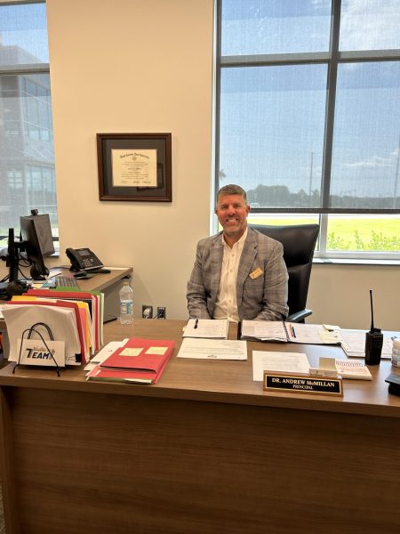 New Spartanburg High School principal Dr. Andrew McMillan smiles in his office.