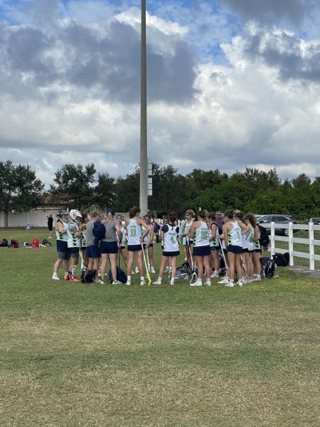 Huddling up after the game, the Green Light Elite girls lacrosse team talks about their performance. Lacrosse is being added to the Olympic games.