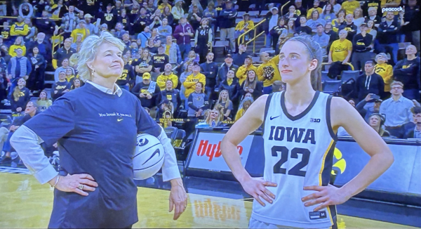 During a television broadcast, Caitlin Clark and Coach Lisa Bluder pose for a photo after Clark beat the NCAA womens career scoring record.