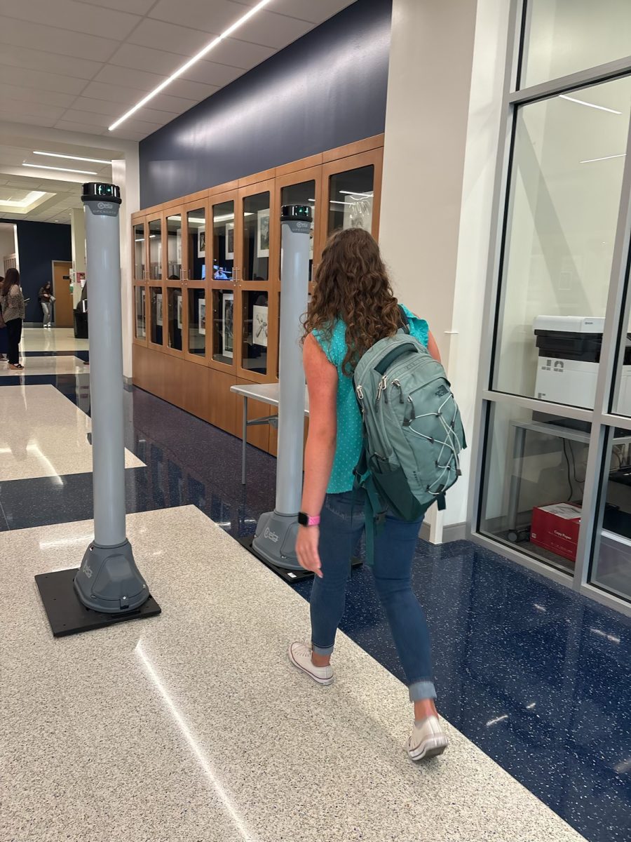 Molly McAbee (12) walks through the metal detector at the entrance of the school.