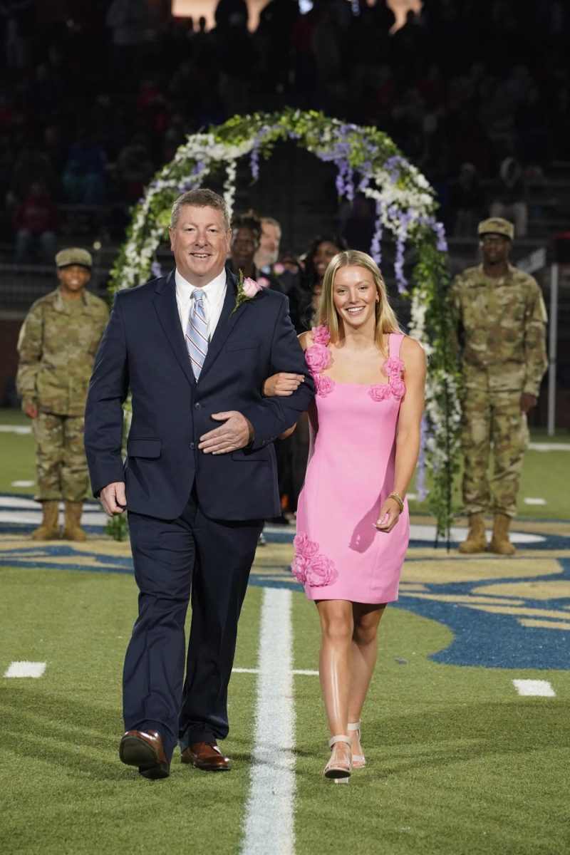 Caroline Byers (12) walks with her father as she is introduced to the crowd.