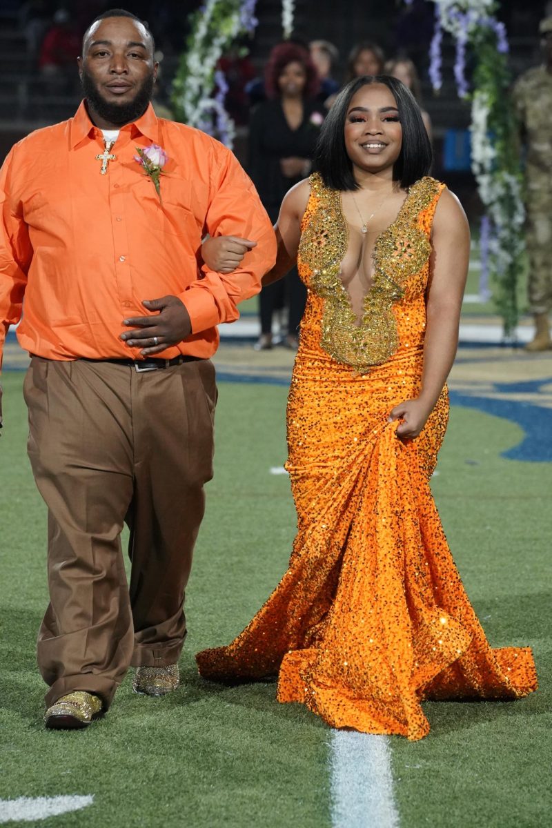 Blessing Littlejohn (12) smiles with her father as they walk down the field. 