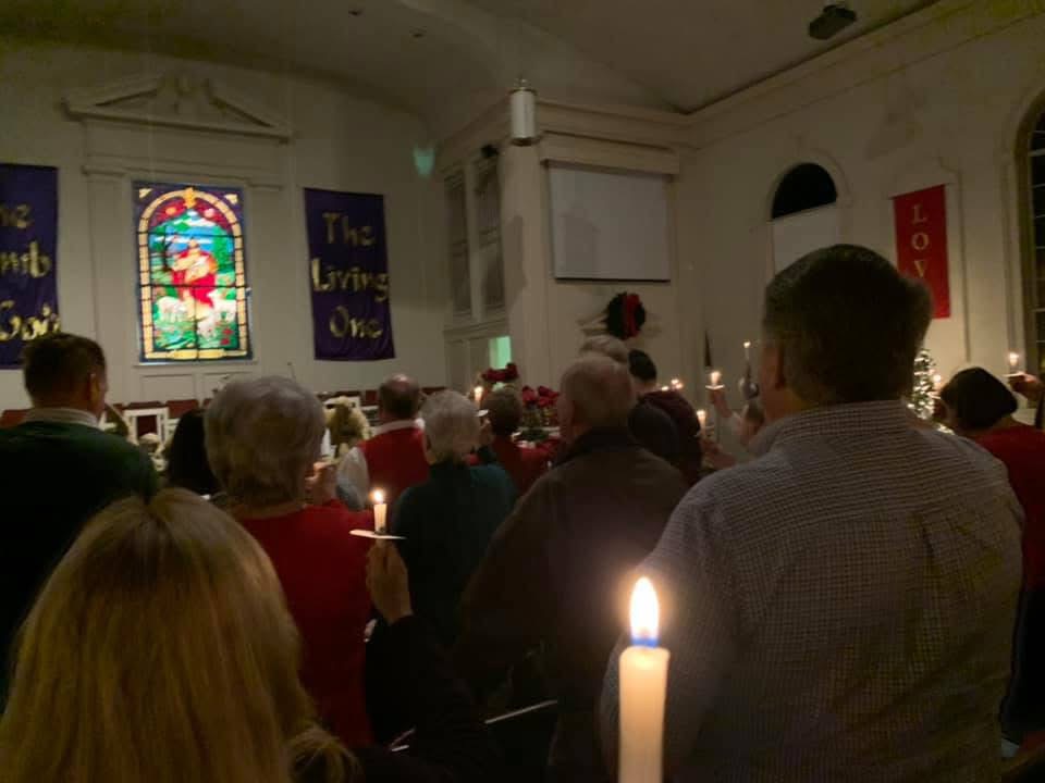 A local church holds a Candle-light Service, a treasured holiday tradition.