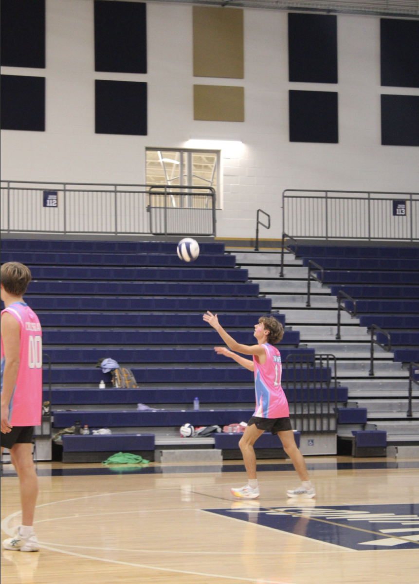 Walker Nunes (12) serves the volleyball to the other side, starting a rally. 