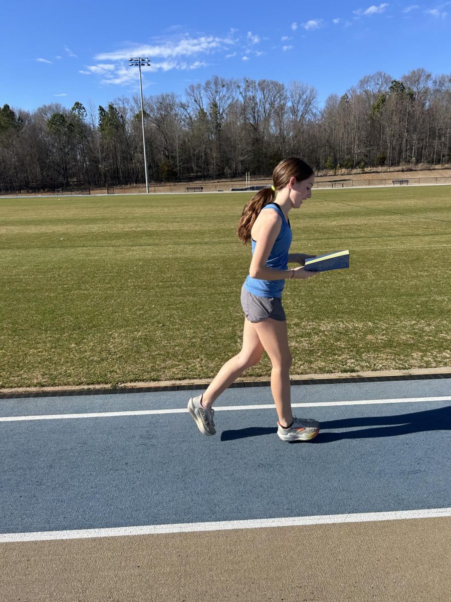 Emmy Dyar (9) runs while reading on the track at Spartanburg High School.