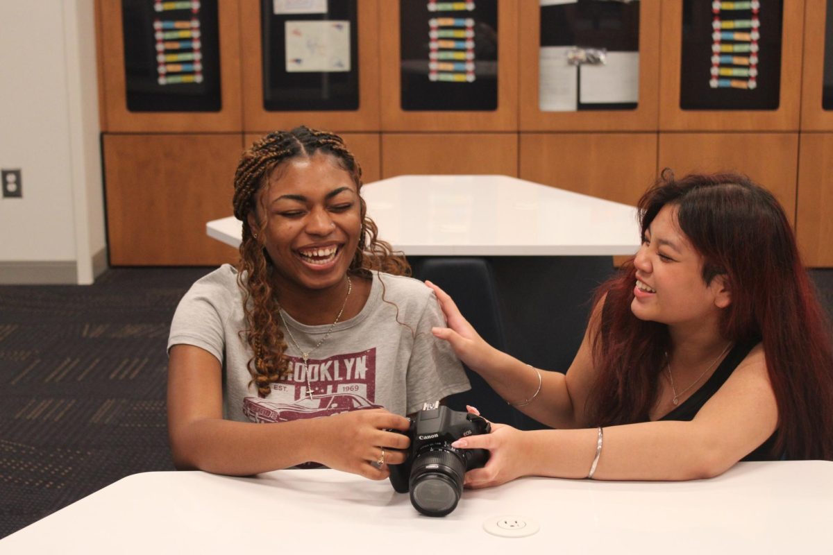 Sharing a laugh, Patience Colon (11) and Maleena Keut (11) practice capturing photos for yearbook class.