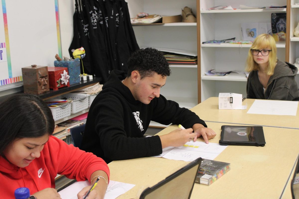 Juan Agudelo (12) works alongside of his classmates on an art assignment in teacher Beth Walsh's classroom.