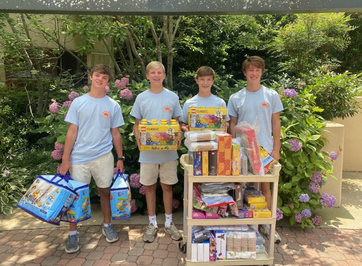 Tradd Hodge (9), founder of The Giver Foundation, and Jack Fairey (9) pose with donations with other volunteers.