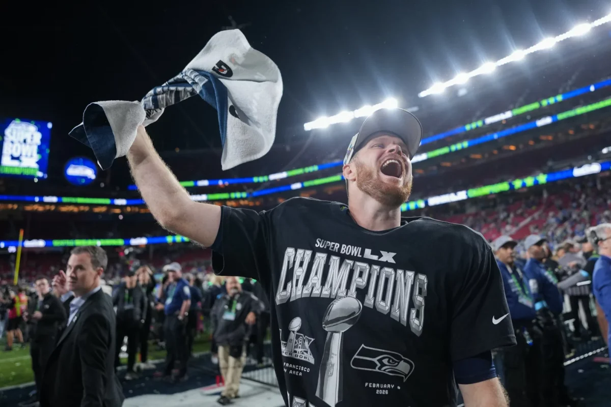 Seattle Seahawks quarterback, Sam Darnold, hoists the Lombardi Trophy after the victory over the Patriot in Super Bowl LX.