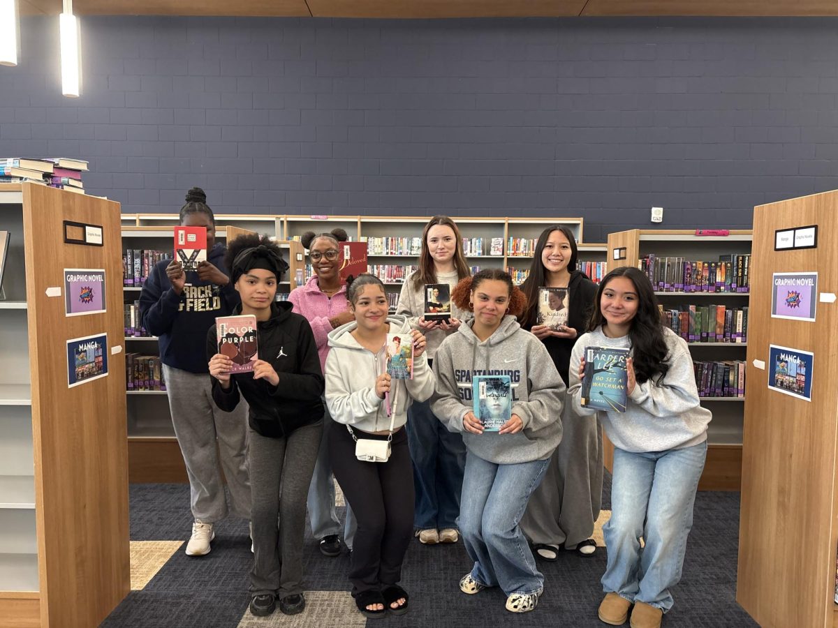 Members of the Women's Literature class at SHS show off their books by female authors as part of an independent study.
