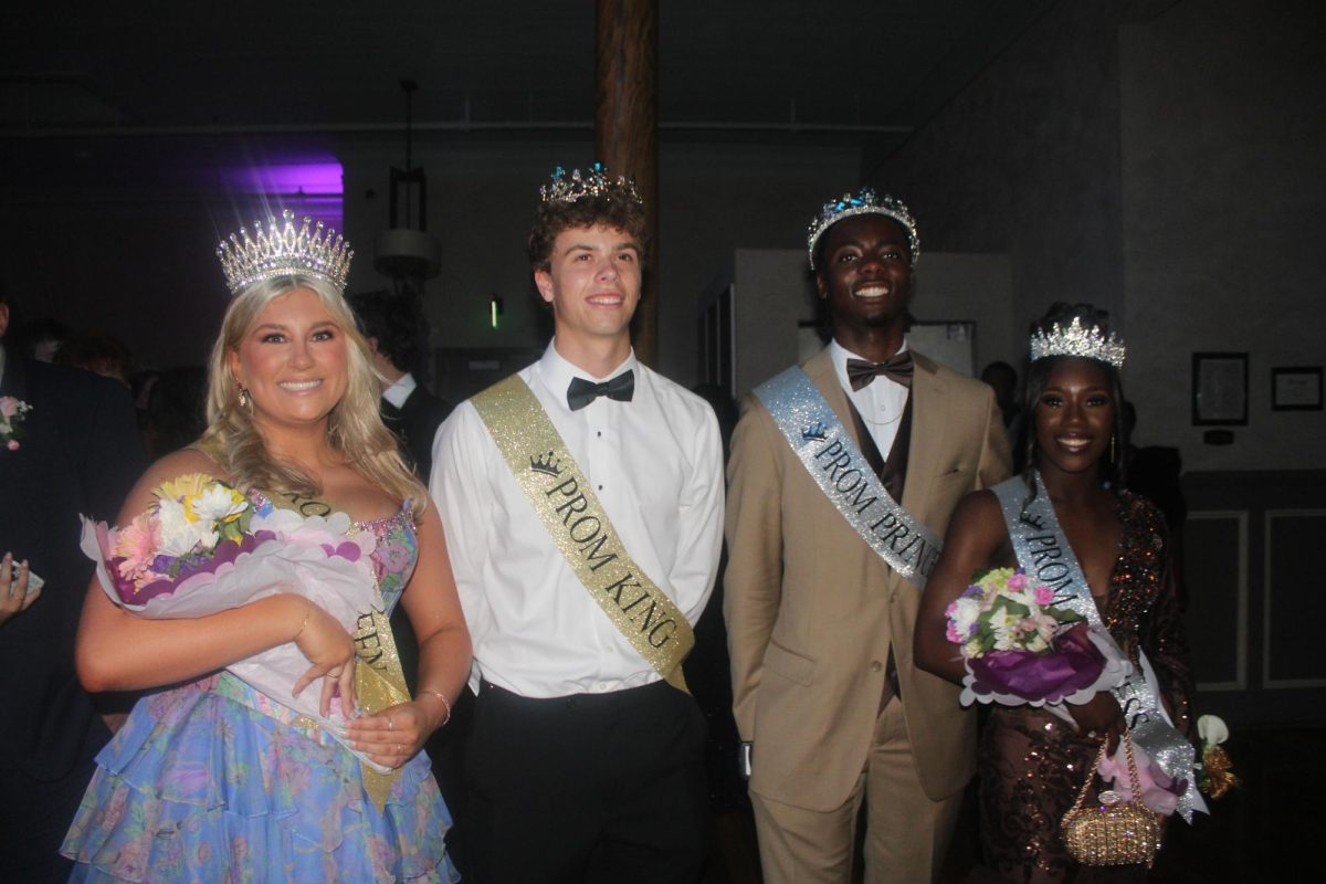 The prom queen, king, princess and prince gather together to take a commemorating photo.
