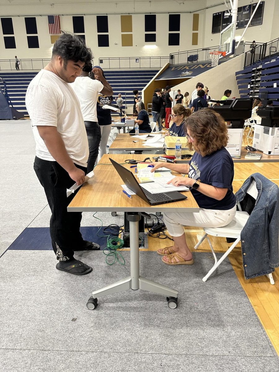 Dwayne Alanzo (12) checks in with staff during the school’s beginning‑of‑year class registration.